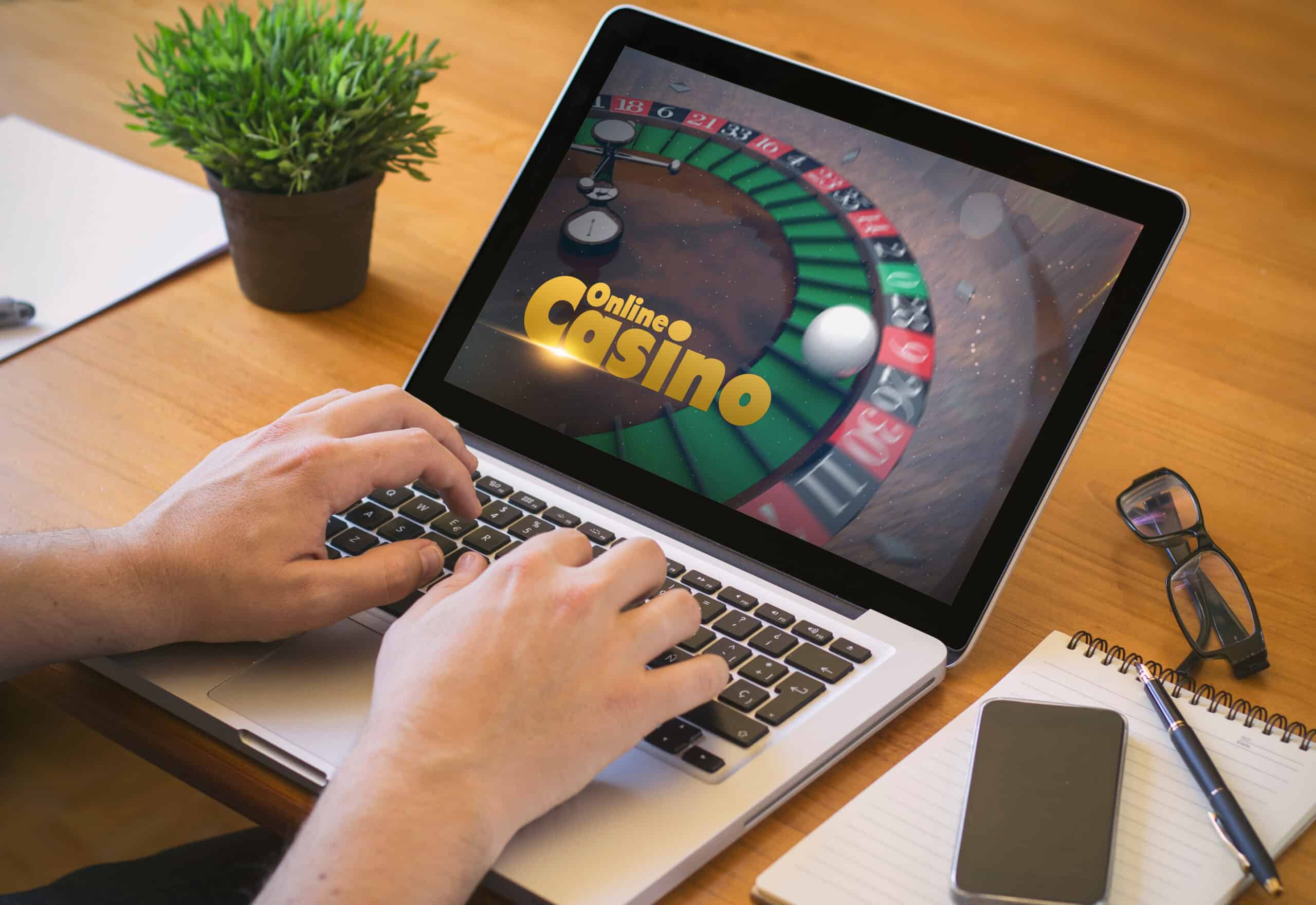 Osoba koristi prijenosno računalo s prikazom online kasino igre